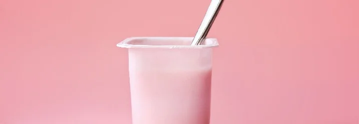 Rosa Joghurt mit Löffel
